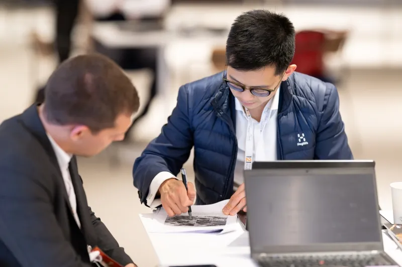 Mining industry professionals reviewing project documents during a 121 Mining Investment meeting